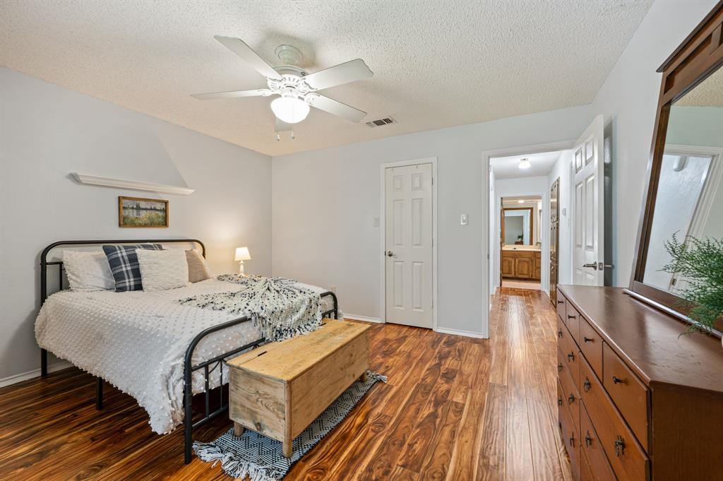 Wood-finish flooring, ceiling fan with integrated lighting, and multiple interior paneled doors