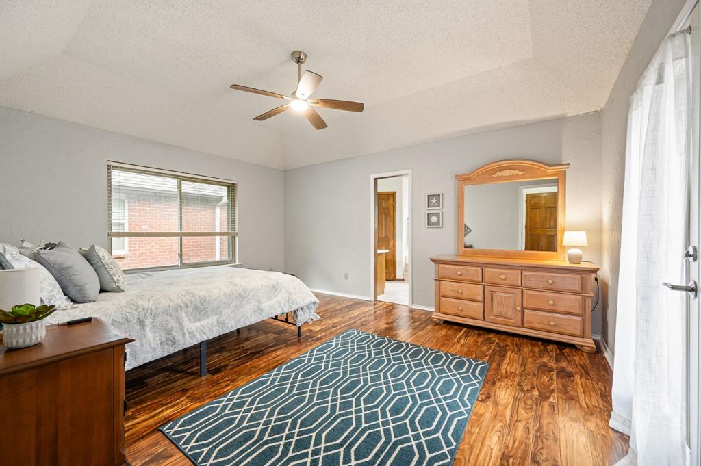 Tray ceiling, wood-finish flooring, sliding glass door, and ceiling fan