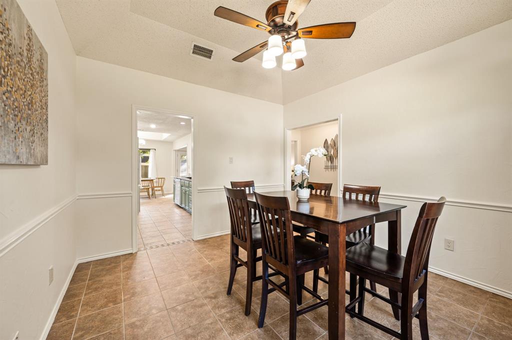 Vaulted ceiling with a central multi-light ceiling fan and decorative chair rail molding