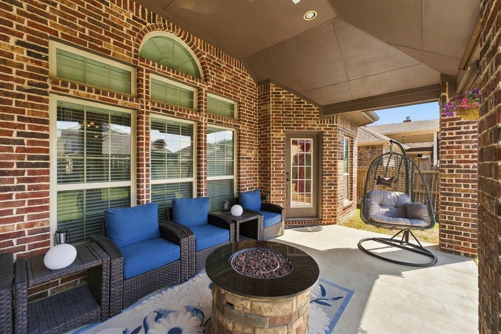 Covered brick patio featuring a vaulted ceiling, recessed lighting, and large windows with arched transoms