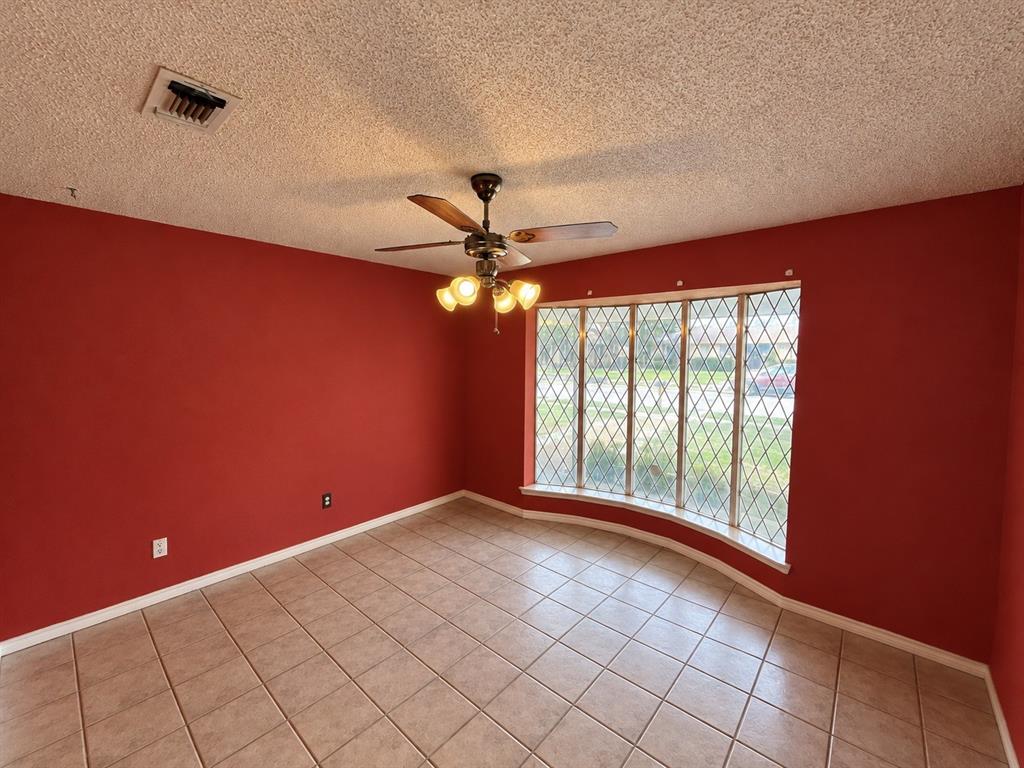Bay window with diamond-patterned muntins, ceramic tile flooring, and a ceiling fan with integrated lighting Bay window with diamond-patterned muntins, ceramic tile flooring, and a ceiling fan with integrated lighting