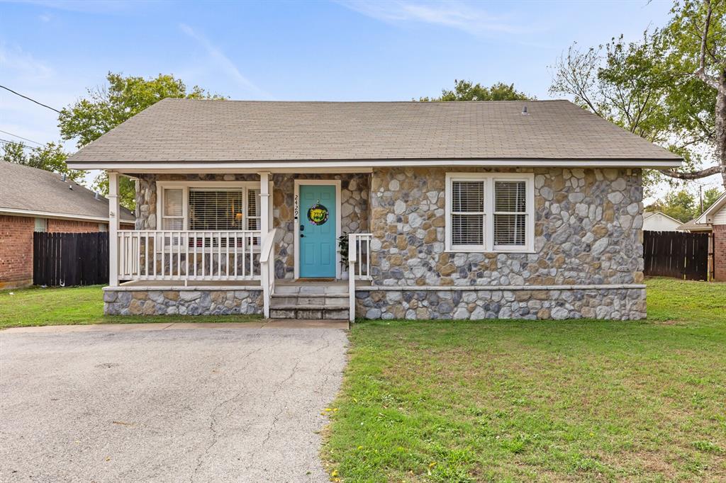 Stone veneer exterior, covered front porch with white railing, and a paved driveway Stone veneer exterior, covered front porch with white railing, and a paved driveway