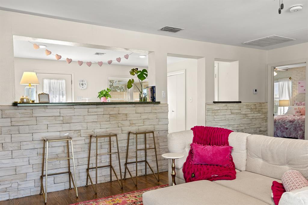 Stacked stone partition walls with dark countertops and wood-finish flooring