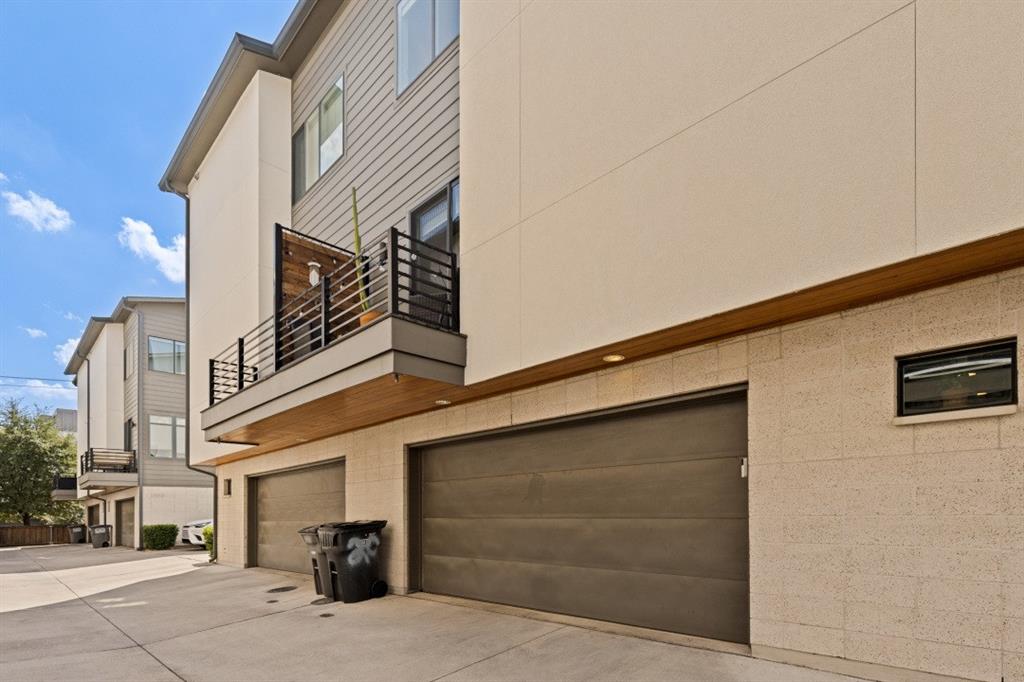 Contemporary multi-story exterior featuring a mix of horizontal lap siding and smooth stucco finishes, a private balcony with horizontal metal railing, wood-accented soffits, and a multi-car garage with overhead doors