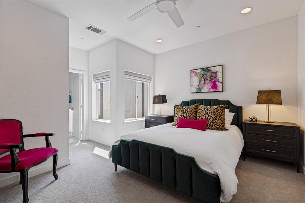 Neutral-toned carpeting, recessed ceiling lighting, dual windows with fitted shades, and a ceiling fan