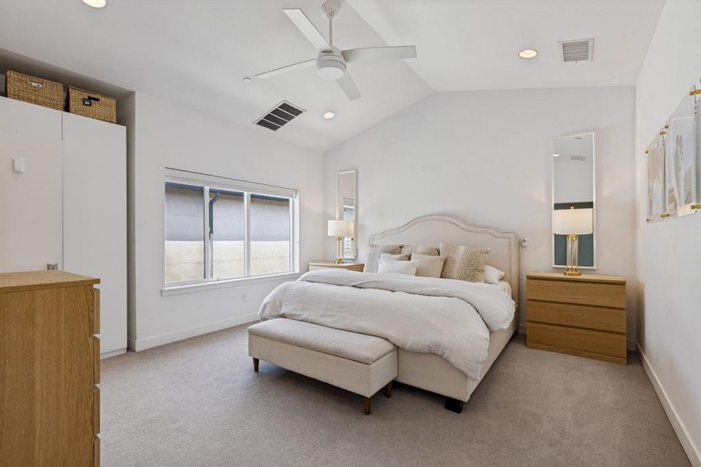 Vaulted ceiling featuring a central white paddle fan, recessed lighting, neutral carpeting, and built-in white wardrobe cabinetry