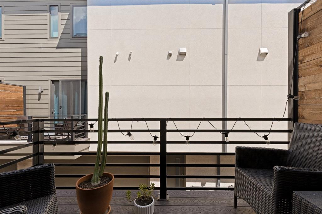 Outdoor deck featuring wood-finish decking, horizontal metal railings, and natural wood privacy fencing