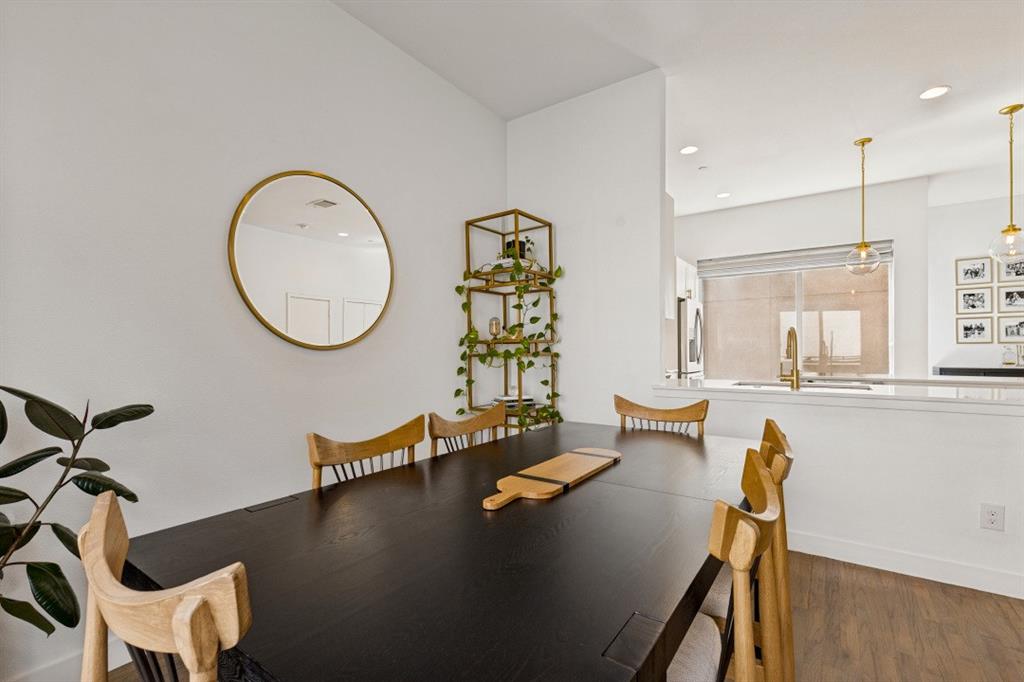 Wood-finish flooring, recessed lighting, and dual pendant light fixtures with metallic accents