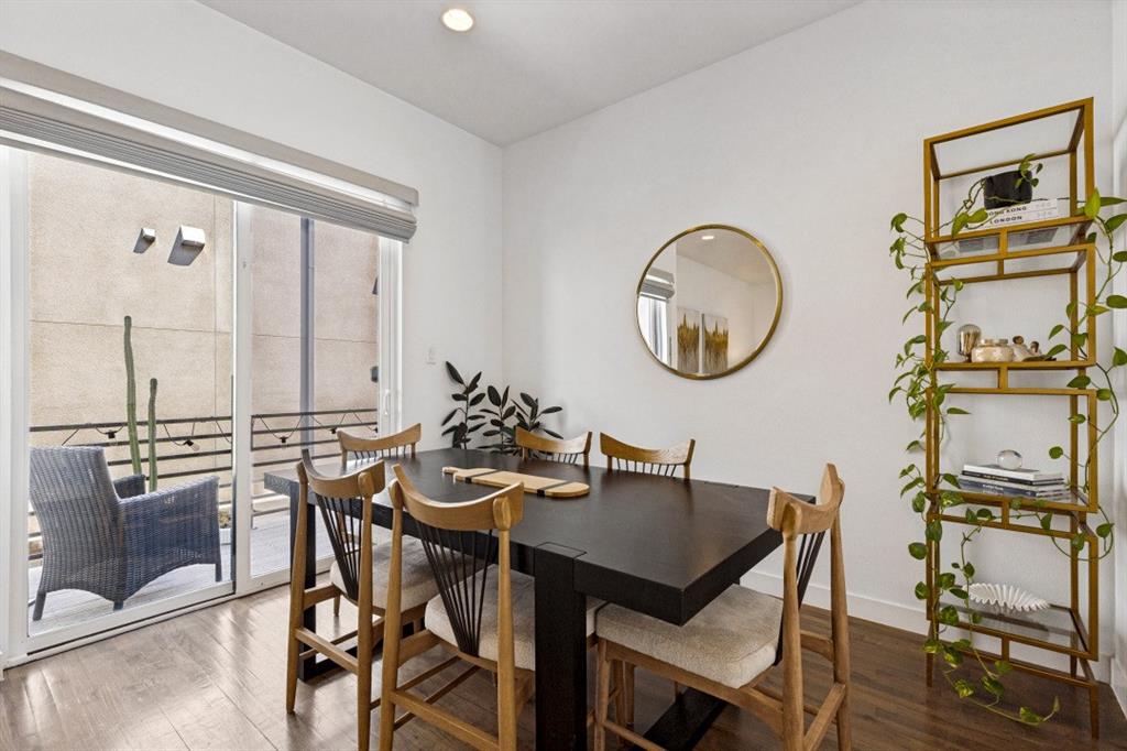 Wood-finish flooring, sliding glass door, recessed lighting, and wall-mounted circular mirror