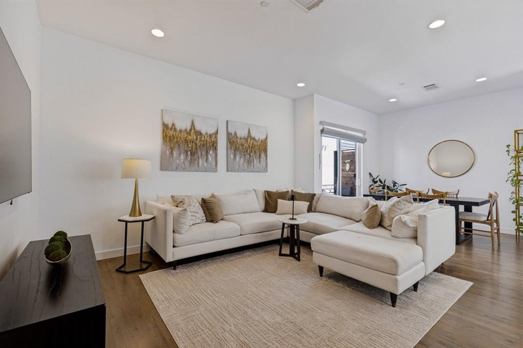 Open-concept interior featuring wood-finish flooring, recessed lighting, and sliding glass doors