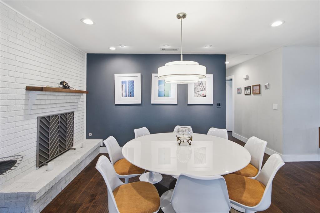 Imagine gathering around the table for a memorable dinner with the warmth and ambiance of a real wood-burning fire nearby. The fireplace features a convenient gas starter and distinctive geometric-patterned screen, while the contemporary pendant light creates a striking focal point above the dining table. With room for eight as pictured, this thoughtfully designed space is equally suited to intimate dinners, holiday celebrations, and lively evenings with friends.