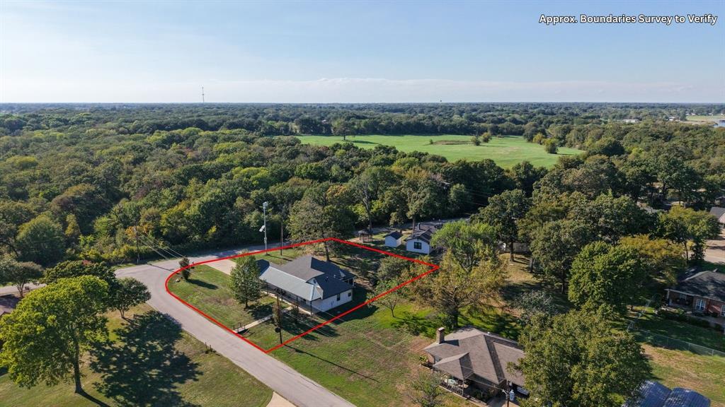 Aerial view highlighting the home's corner lot and surrounding wooded setting. Aerial view highlighting the home's corner lot and surrounding wooded setting.