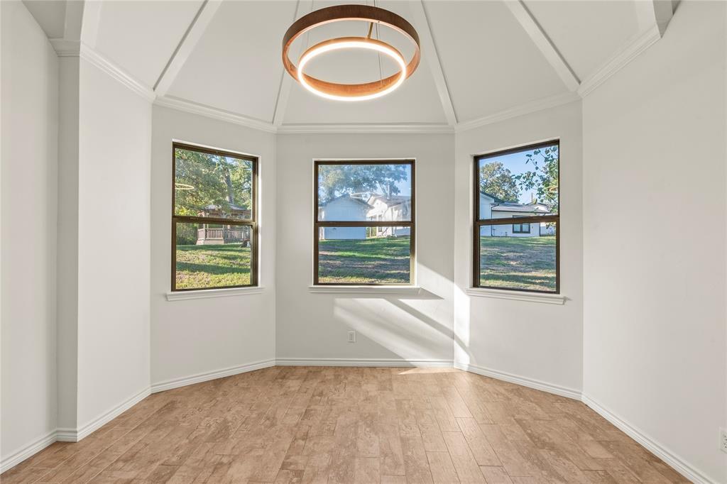 Another view of the dining area highlighting the unique ceiling design and large windows.