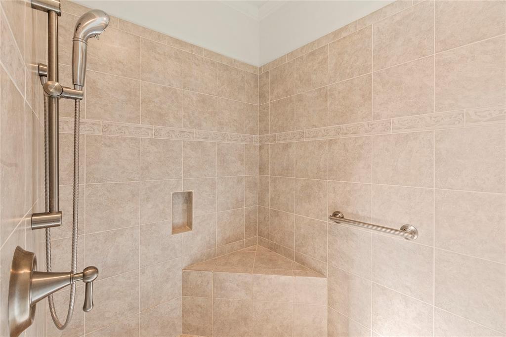 Ensuite bathroom two with double-sink granite vanity, generous cabinet storage, and walk-in tiled shower.