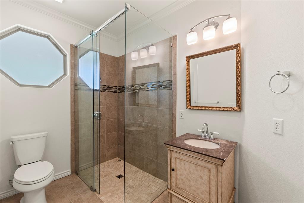 Ensuite bathroom One featuring a tiled walk-in shower with glass enclosure and decorative vanity.