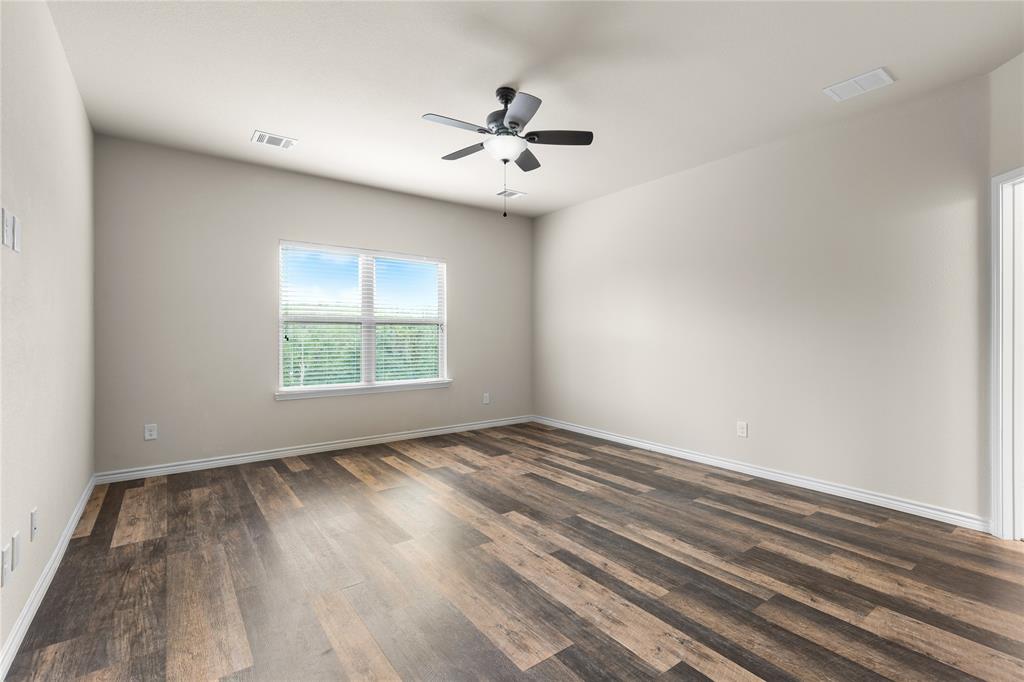 Room featuring neutral wall paint, wood-finish flooring, a multi-blade ceiling fan with integrated lighting, and a window with horizontal blinds