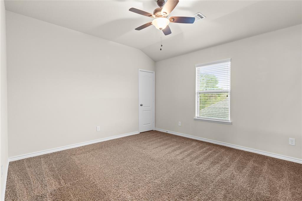 Interior room featuring vaulted ceilings, neutral-toned wall paint, wall-to-wall carpeting, an integrated ceiling fan with light fixture, and a single-pane window with horizontal blinds