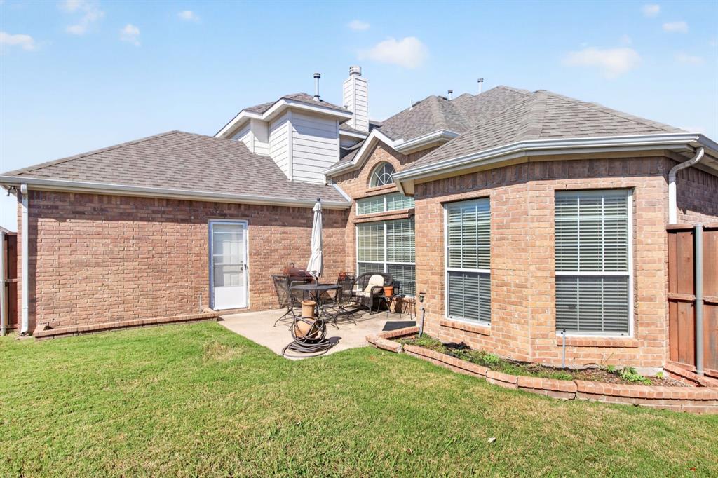 Rear exterior view showing the brick facade, patio and lawn.