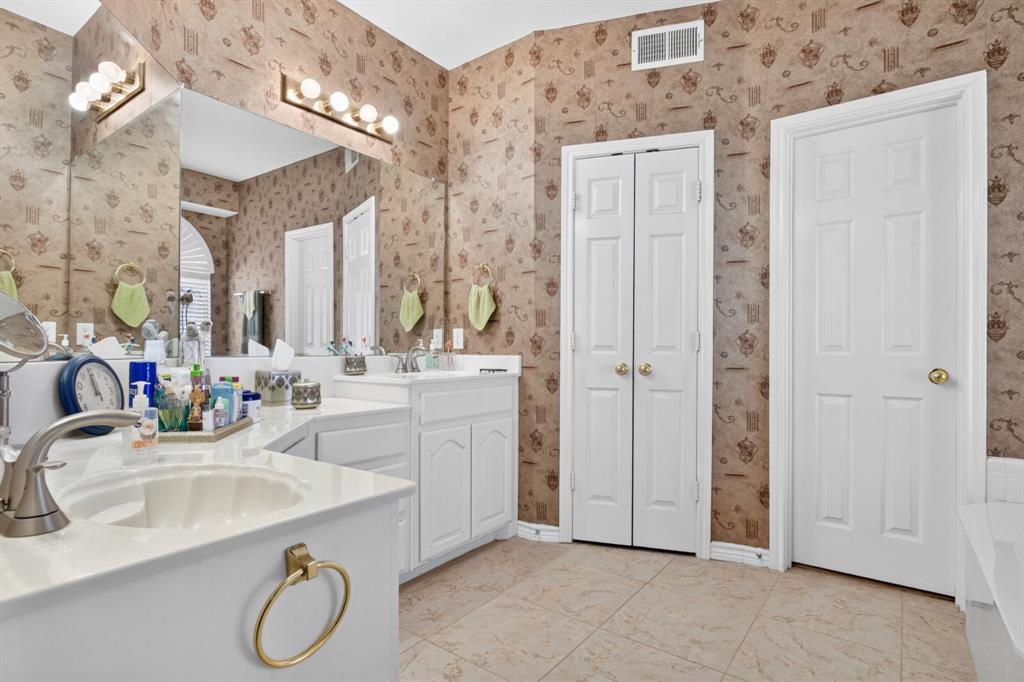Primary bathroom with a long vanity, dual sinks and ample mirror space.