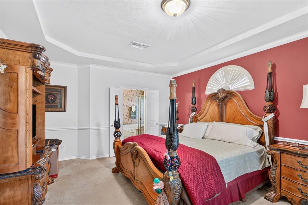 Primary bedroom with a tray ceiling, generous floor space and an adjoining bathroom. Primary bedroom with a tray ceiling, generous floor space and an adjoining bathroom.