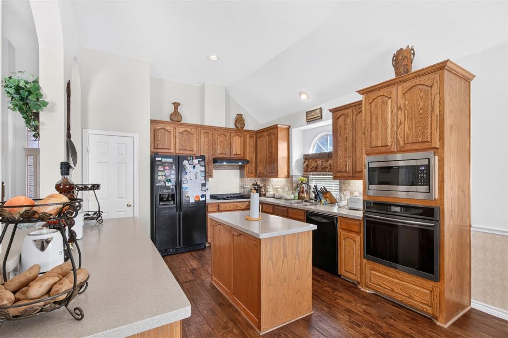 Alternate kitchen view highlights the gas cooktop, built-in ovens and island.