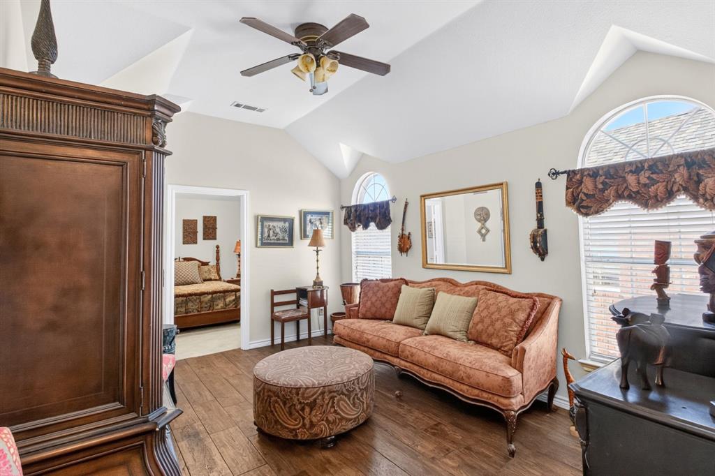 Additional living area with a vaulted ceiling and arched windows.