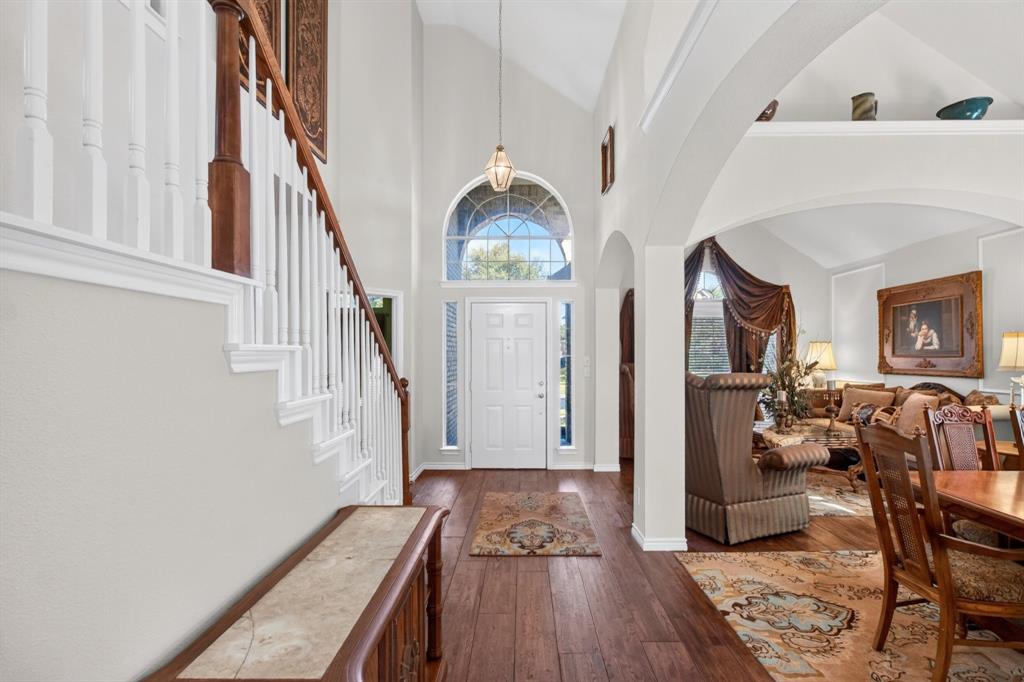 Bright entry with a tall arched window and an open staircase. Bright entry with a tall arched window and an open staircase.