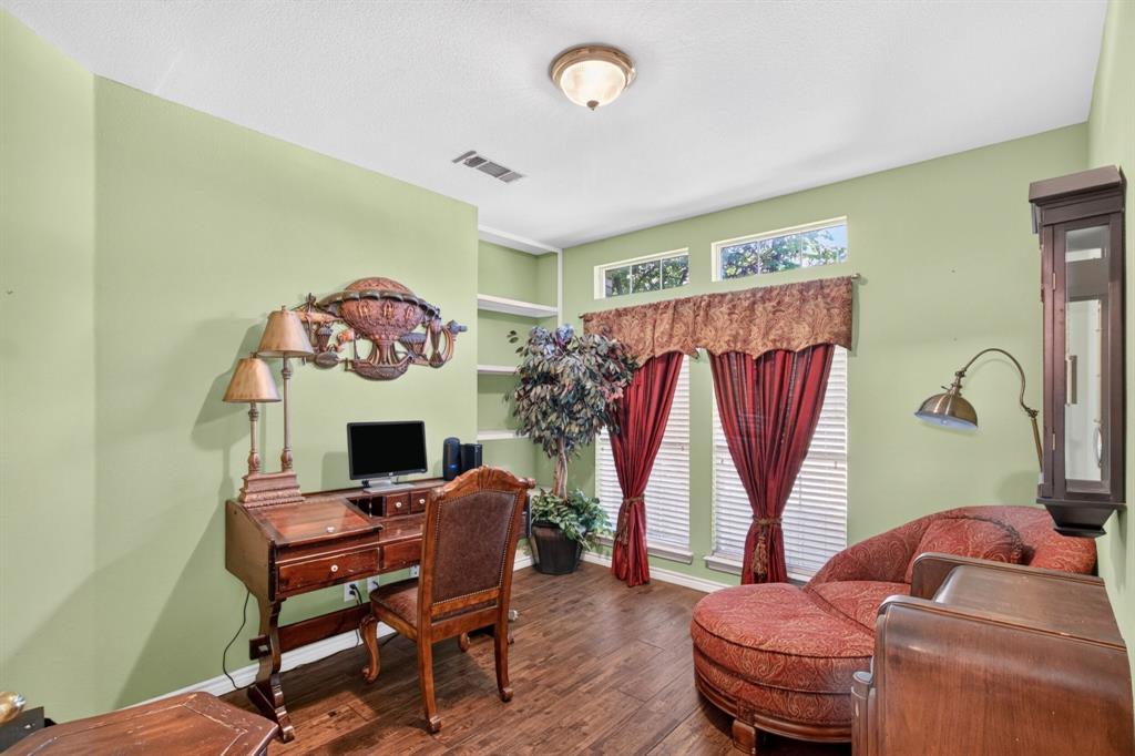 Home office space with built-in shelving and a large window.
