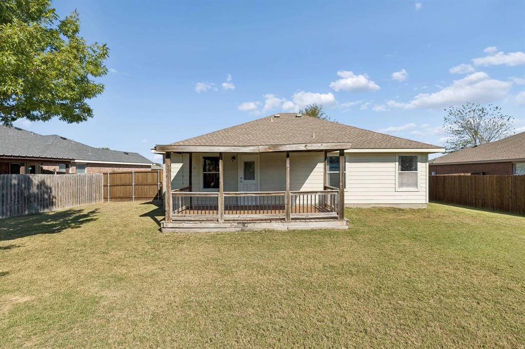 View of the backyard showcasing the covered patio.