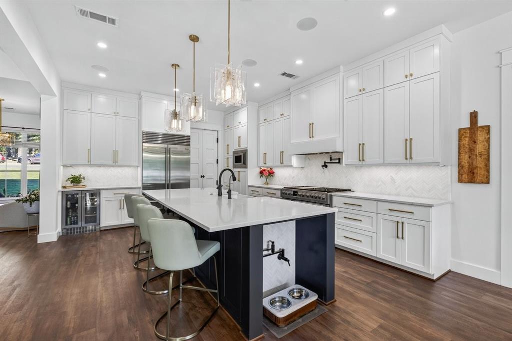 Beautifully designed kitchen with quartz countertops, custom cabinetry, oversized island, and stainless steel appliances. Yes, that is a pot filler for your pups! Main Residence.