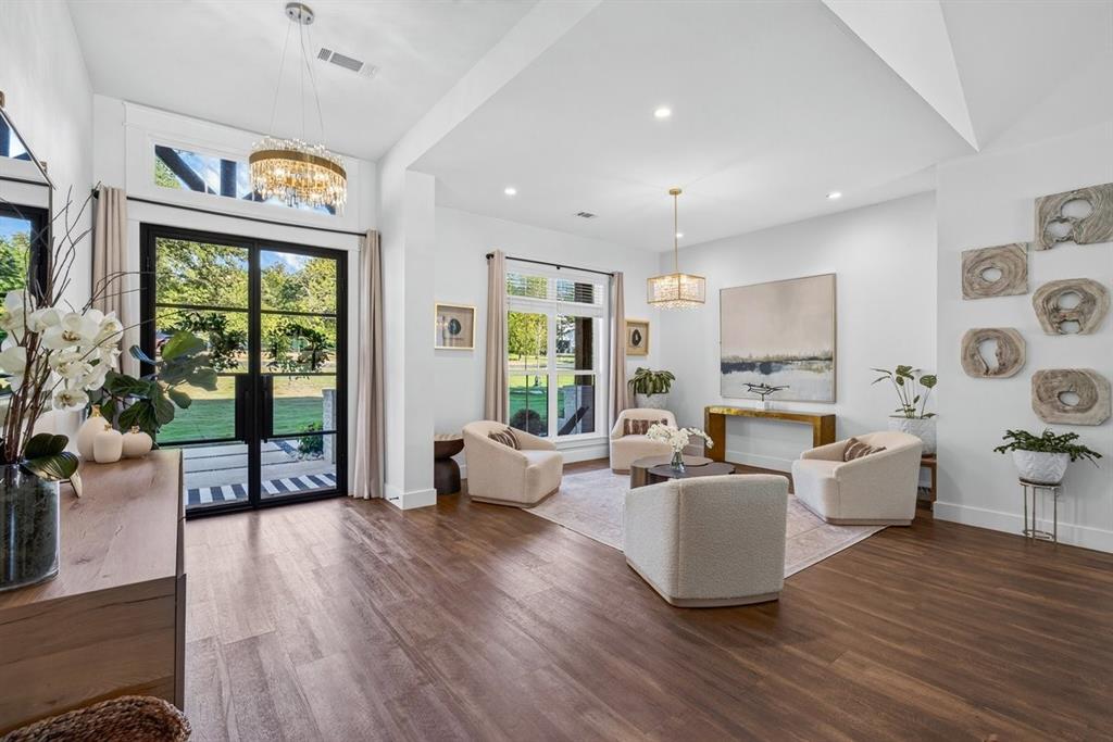 Grand entryway with soaring ceilings, elegant chandelier, and a welcoming sitting area or formal dining space. Grand entryway with soaring ceilings, elegant chandelier, and a welcoming sitting area or formal dining space.
