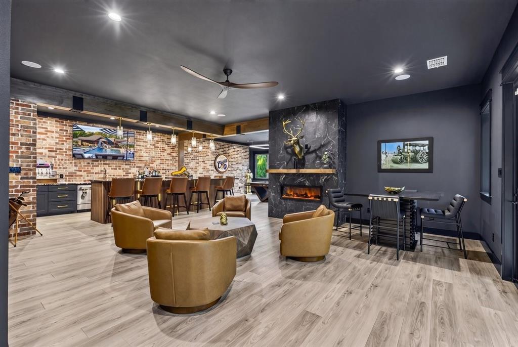 Detached lounge room featuring a full bar, fireplace, lounge seating, and game room.