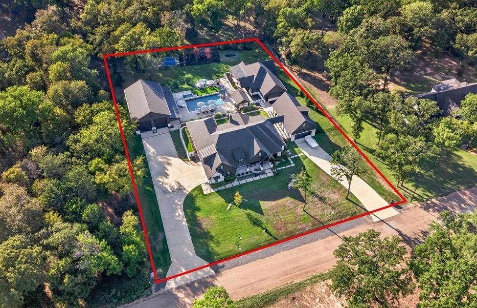 Aerial view showcasing the property's impressive layout, multiple structures, expansive outdoor amenities, and wooded surroundings. Aerial view showcasing the property's impressive layout, multiple structures, expansive outdoor amenities, and wooded surroundings.