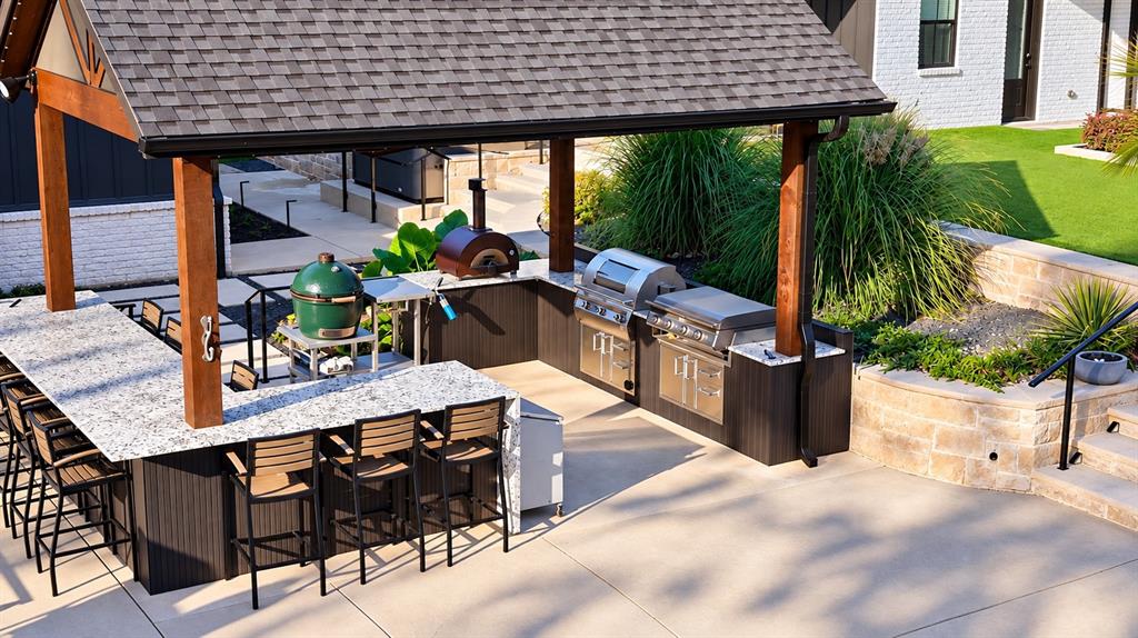 Fully equipped outdoor kitchen with Alfa pizza oven, Blackstone griddle, gas grill, beverage refrigerator, and under-bar lighting. Barstools convey with the property.
