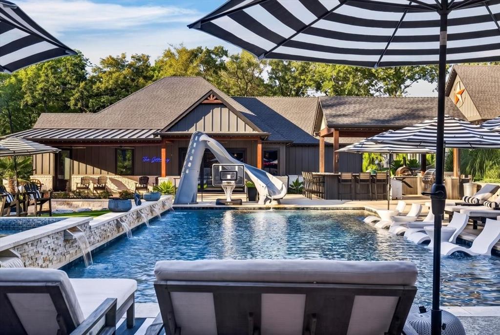 Outdoor oasis with heated and chilled salt water pool with water slide and hot tub.