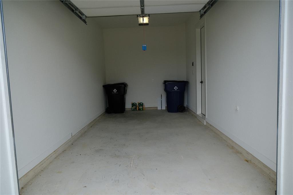 Attached second garage featuring concrete flooring, crisp white walls, and a dedicated entry door