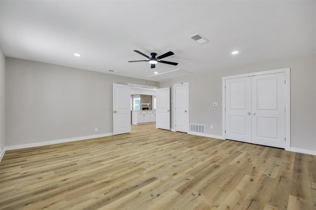 Spacious room featuring wood-finish flooring, recessed lighting, a ceiling fan, and double-panel doors