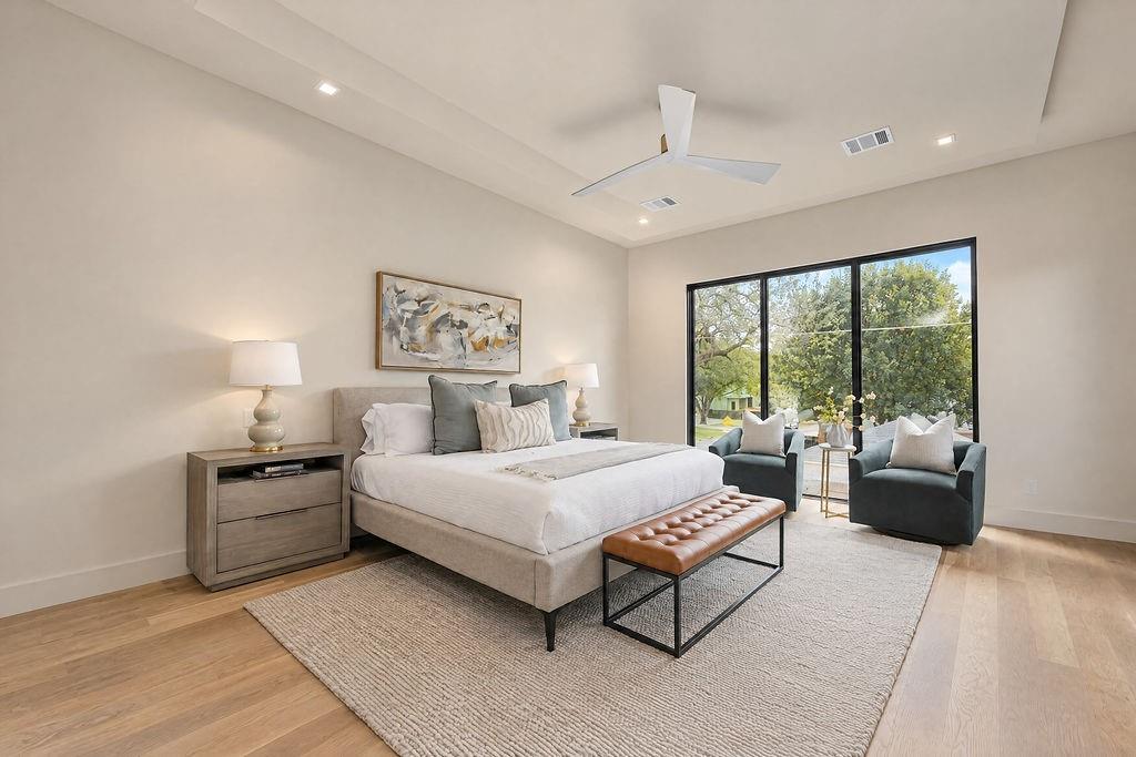 Sleep deeply in a private primary retreat featuring quiet views and a breezy ceiling fan