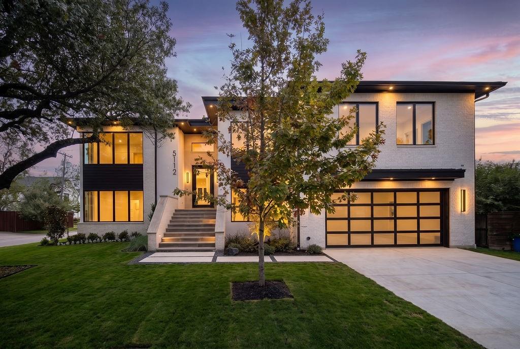 Experience new construction contemporary architecture in Dallas's prestigious Bird Streets, featuring clean architectural lines, warm wood accents, and Hubbardton Forge Carbon exterior sconces that welcome you home each evening