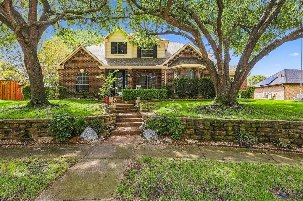 Stately curb appeal with a home framed by towering mature trees.