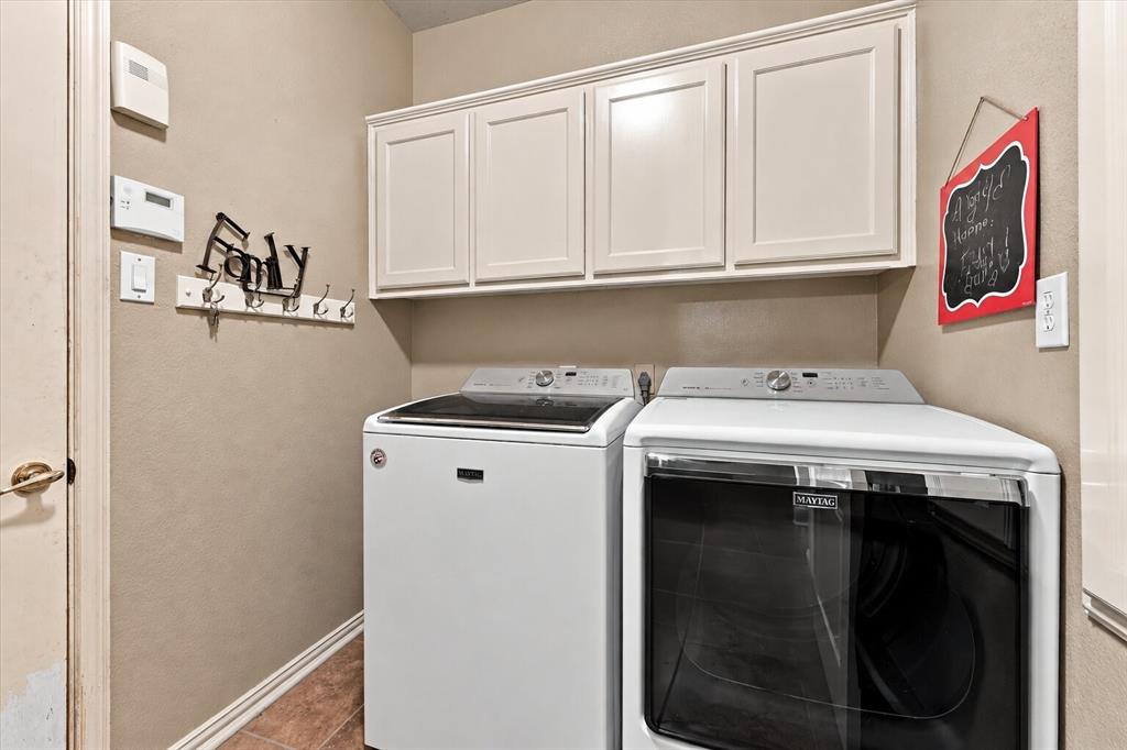 Laundry room with cabinetry for extra storage.