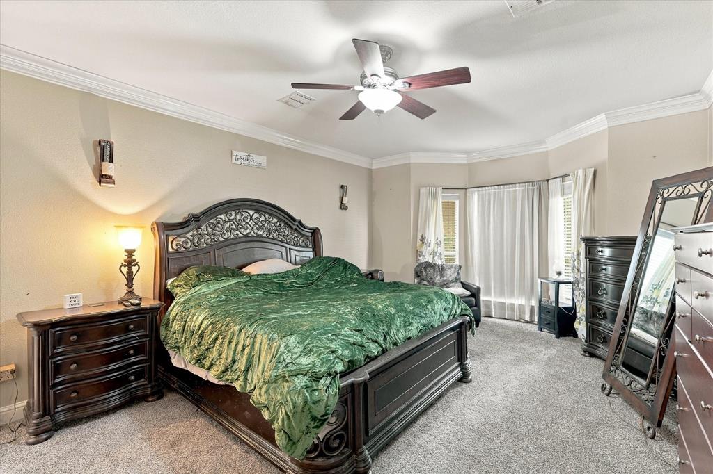 Primary bedroom with bay window overlooking shaded front yard and cul-de-sac.