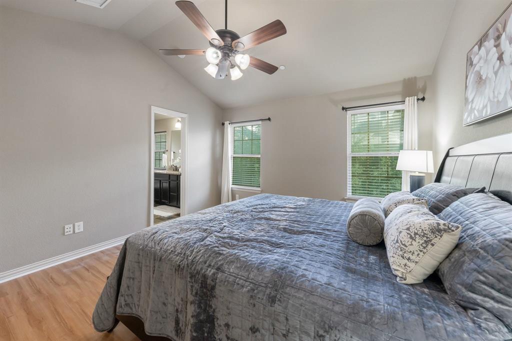 Vaulted ceilings, wood-finish flooring, and a multi-blade ceiling fan with integrated lighting