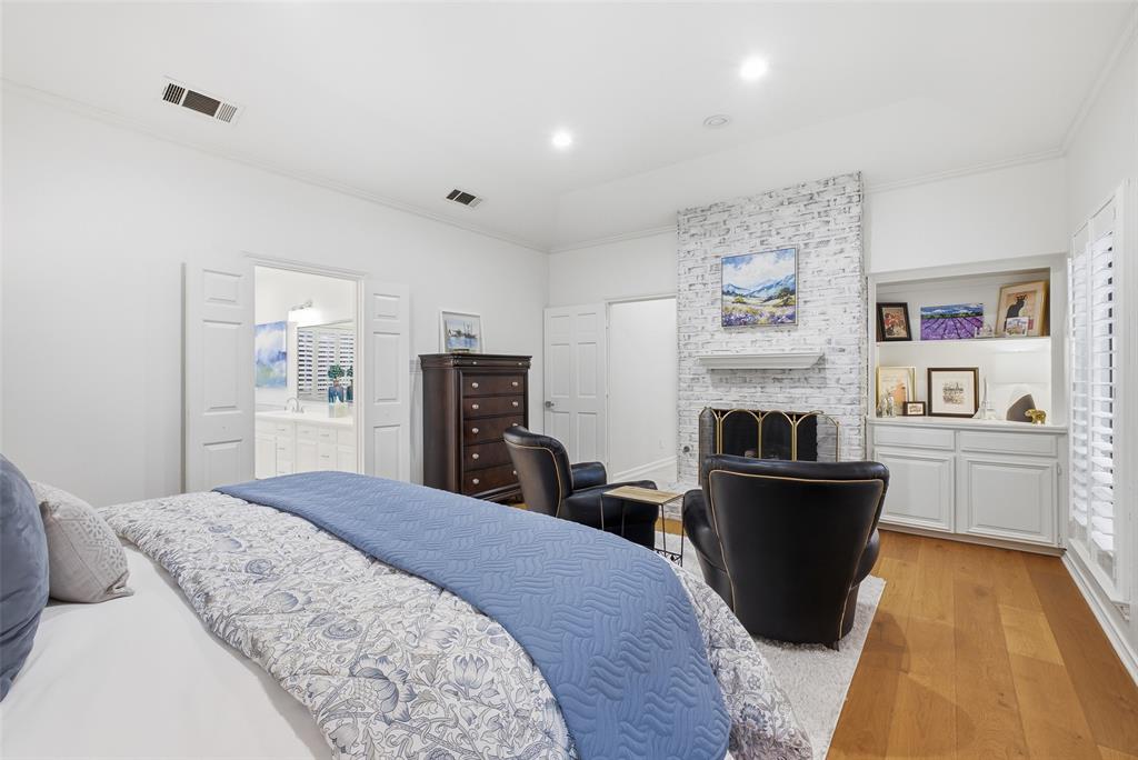 A whitewashed brick fireplace and built-in cabinetry give the primary suite boutique-hotel style.