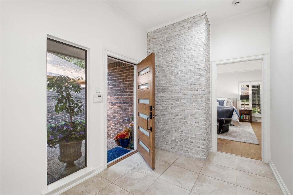 Bright foyer with a whitewashed brick accent wall—style greets you before you even set down your keys.