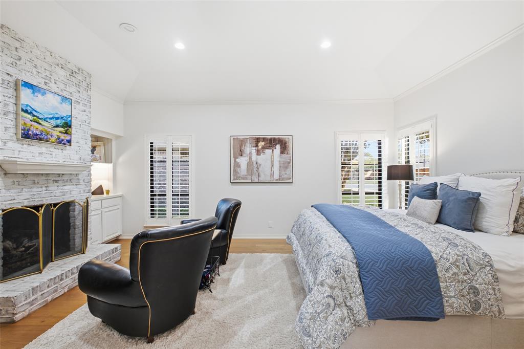 Vaulted ceiling, fireplace, and plantation shutters—the primary suite is pure relaxation.