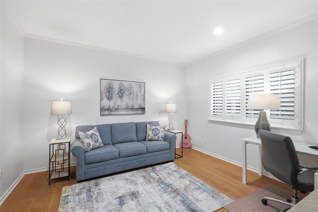 Secondary bedroom with plantation shutters and wood floors—ideal as a guest room, office, or both.