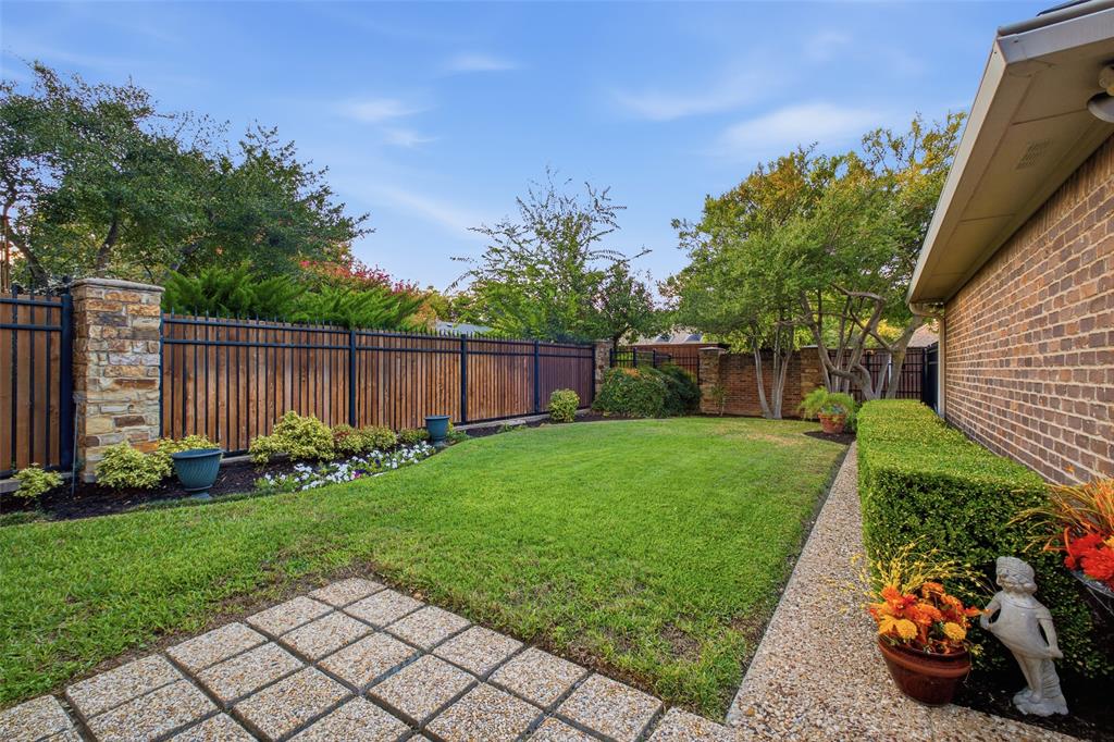 Mature trees, landscaped beds, and a privacy fence make the yard feel like your own private park.