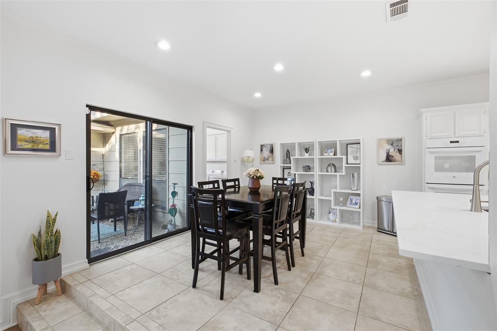 Breakfast nook with built-in display shelving and a sliding door to the courtyard patio—morning coffee, al fresco.