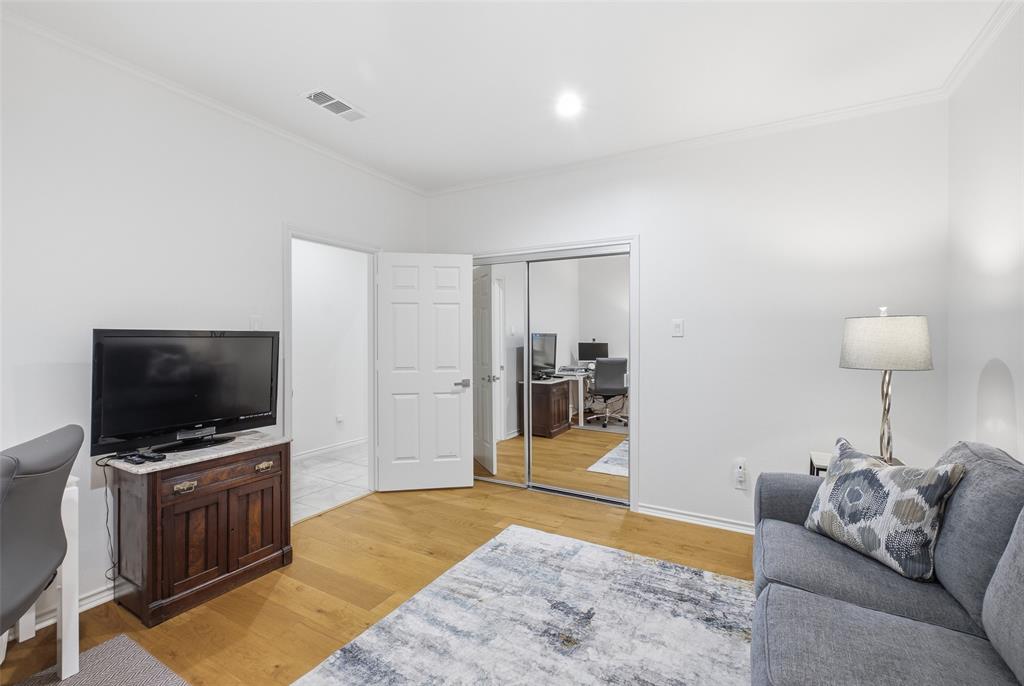 Mirrored closet doors and wide-plank floors make this secondary bedroom bright and flexible.